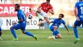 Fran Carnicer, del Linares Deportivo, trata de presionar a un rival del Real Murcia que dispara a portería.