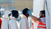 Un miembro de Cruz Roja atiende a un grupo de inmigrantes llegados al puerto de Málaga, en una imagen de archivo. / Europa Press.