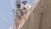 OPERARIOS. Obreros trabajan en el tejado durante una construcción.