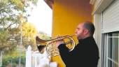 ARTISTA. El músico Alejandro Huete interpreta una marcha desde su balcón.