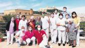 FELICIDAD. Cariño Robles posa con otras mujeres mayores y personal de la residencia, con La Mota al fondo.