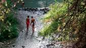 Dos niños se refrescan durante un caluroso día de verano en Los Cañones del Río Frío. / 