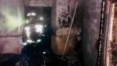 FUEGO. Un bombero sofoca las llamas en la vivienda de Los Villares.