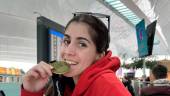 Marta López muerde su medalla delante de su trofeo. / RFEB.