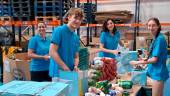 Varios voluntarios de Fundación La Caixa ordenan productos en el Banco de Alimentos de Jaén.