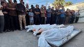 Un grupo de personas contemplan los cuerpos de otros gazatíes fallecidos en un ataque israelí, frente el hospital Shuhada al Aqsa de Deir al Balá, en el centro de la Franja de Gaza. / Europa Press.