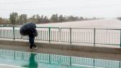 Una persona cruza por el Puente de la Señorita cortado al tráfico por el desbordamiento parcial del río Guadalquivir a su paso por la Cartuja este fin de semana. / Eduardo Briones / Europa Press.