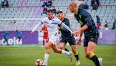 El jugador del Real Jaén Adri Paz avanza con el balón entre dos rivales del Almería B. / David Torres / Real Jaén CF.
