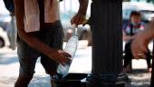 Un hombre rellena una botella de agua en una fuente / David Zorrakino / Europa Press.
