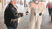 PROTECCIÓN. Un voluntario de Protección Civil entrega una mascarilla a un hombre en la estación.