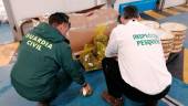 Agentes de la Guardia Civil con la mercancía intervenida. 