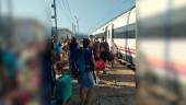 Afectados por la avería esperan fuera de uno de los trenes. 