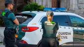 Dos agentes y un coche de la Guardia Civil, en una imagen de archivo. / Guardia Civil. 