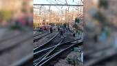 Pasajeros de Cercanías pasean por las vías tras las incidencias en el tendido eléctrico. 