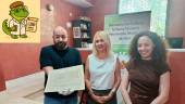 Alejandro Romero, María Espejo y Yolanda Milla muestran el documento histórico. En la esquina superior izquierda, la figura de Magdaleno.