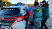 Agentes de la Guardia Civil introducen en el coche a uno de los detenidos por el homicidio de un hombre en Chiclana para robarle droga. / Guardia Civil.