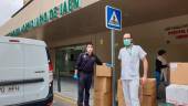 Un agente de la Policía Nacional entrega el material sanitario a un enfermero en el hospital Ciudad de Jaén.