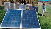Los paneles solares que abastecen de energía a la finca y la vecina Lourdes Perona, en su explotación ganadera delante de sus ovejas. 