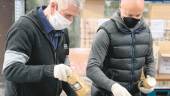 COMIDA. Dos voluntarios organizan los alimentos no perecederos antes de ofrecerlos a las familias.