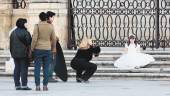 EN LA CAPITAL. Una fotógrafa inmortaliza a una niña vestida de comunión en la Plaza de Santa María ante la mirada de su familia en una foto de Archivo.