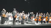 El director de la Joven Orquesta Sinfónica de Jaén, Rafael de Torres, ofrece una reverencia al público al entrar al escenario.