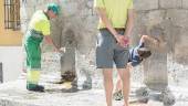 Trabajadores y viandantes se refrescan en la fuente del Pilar del Arrabalejo. Archivo.