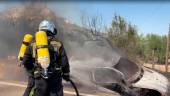 Un bombero apaga el fuego del coche tras el accidente. / Ayuntamiento de Jaén. 