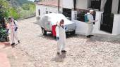LIMPIEZA. Varios operarios desinfectan, con una mezcla de agua y lejía, una de las calles de El Centenillo.