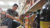 COMPRA. Un consumidor mira el aceite de oliva en un supermercado, en una imagen de archivo.
