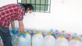 SUMINISTRO. Rubén Castillo recoge garrafas de agua para el abastecimiento de su familia.