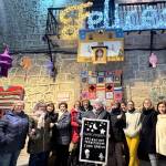 María Lomas, Conchi Ruiz, Laura Cabrera, Juana Bolívar, Montse Gutiérrez, Dolores Lomas, Dori Ruiz, Inma Martínez, Juani Elvira, Rosa Camacho, Rosa Mari Valdivia, Pepi Osorio y Dolores Troya posan junto al tapiz de las astronautas tras la presentación de este proyecto y de la fachada de la ermita de la Virgen de Belén, ambos hechos de ganchillo. / Elisabeth Ruiz / Diario JAÉN.