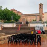 Tres operarios colocan plásticos para proteger de la lluvia el equipo de sonido instalado en la Plaza del Ayuntamiento para la ceremonia. / Fran Miranda / Diario JAÉN. 