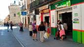 Gente en la calle junto a negocios a oscuras pocos minutos después del inicio del apagón en la Carrera de Jesús.