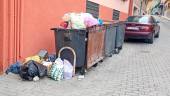 Tres contenedores rebosantes de basura en un día de junio.