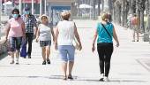 AVANCES. Un grupo de personas con mascarilla camina por el paseo marítimo de la malagueña playa de Huelin durante la fase 2 de la desescalada.