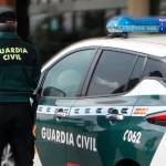Un agente de la Guardia Civil, de espaldas, junto a un vehículo oficial. Archivo. / Guardia Civil.