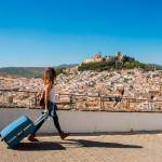 Una turista pasea por Alcalá la Real, con la Fortaleza de la Mota al fondo. / Ayuntamiento de Alcalá la Real.