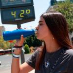 Una joven bebe agua para soportar las altas temperaturas. A 10 de agosto de 2024, en Sevilla. Archivo. / Rocío Ruz / Europa Press. 
