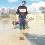 Un vecino de Mengíbar muestra un cerdo y varias gallinas muertas después de la crecida del río a su paso por el municipio. / Archivo Histórico de Diario JAÉN.