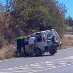 Policías locales y otro conductor auxilian al del vehículo siniestrado.