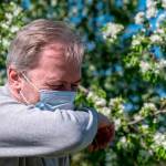 Un hombre con mascarilla estornuda debido a la alergia. / Europa Press.