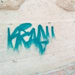 Pintadas sobre la muralla y un panel explicativo del monumento.