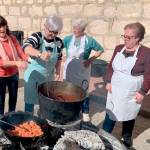 Las matanceras de Solera preparan la masa del chorizo y la morcilla, mientras que el fuego cocina los alimentos que degustaron con ganas y nostalgia los vecinos que acudieron a la I Fiesta de la Matanza de Solera. / Pablo Espinosa Luna / Diario JAÉN.