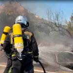 Un bombero apaga el fuego del coche tras el accidente. / Ayuntamiento de Jaén. 
