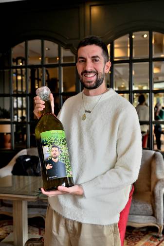 <i>David Broncano junto a una botella de aceite con una etiqueta personalizada.</i>