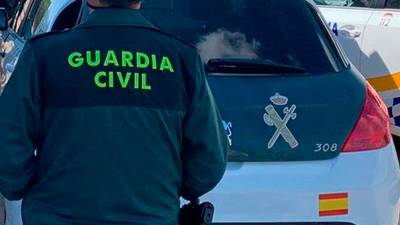 Agente y coche de la Guardia Civil. Archivo. 