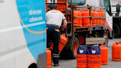 Un repartidor de bombonas de butano carga con una bombona. 