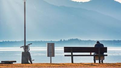 Hombre sentado frente a un gran lago. / Pixabay. 
