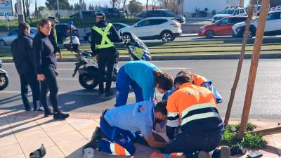 El personal sanitario atiende al motorista tras el accidente.