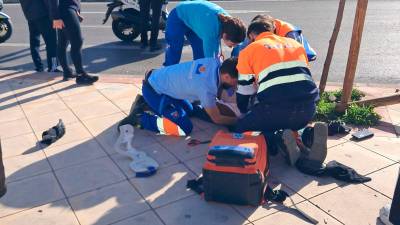 El personal sanitario atiende al motorista tras el accidente.